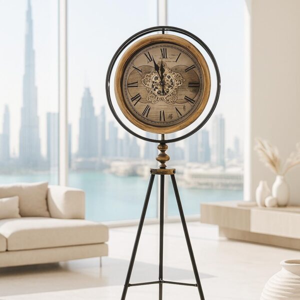 שעון חצובה עומד עם מסגרת עץ טבעי, ספרות רומיות ועיטור מרכזי, בגובה 156 ס״מ על רגלי מתכת שחורות בסלון מודרני.